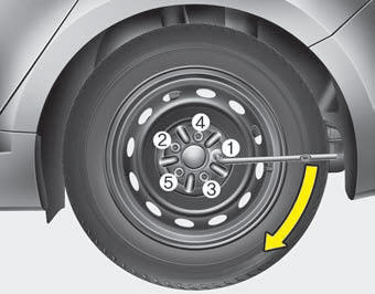 Then position the wrench as shown in the drawing and tighten the wheel nuts.